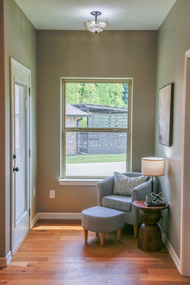 sitting room with baseboards and light wood-style flooring
