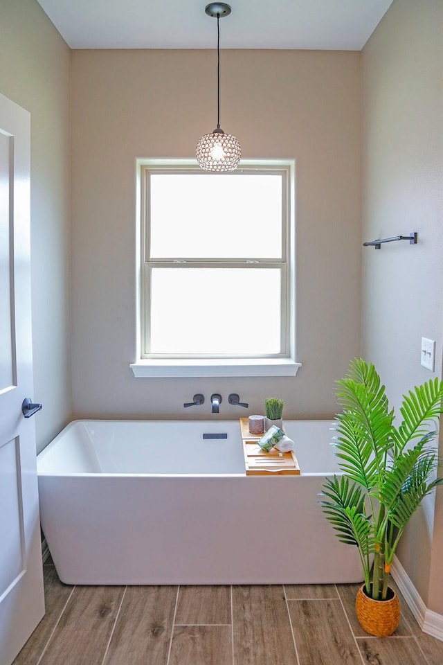 full bathroom with a soaking tub and wood finished floors