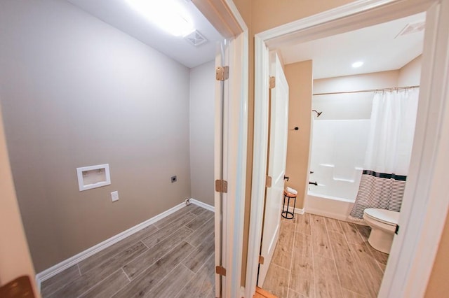 corridor featuring baseboards, light wood-style flooring, and visible vents