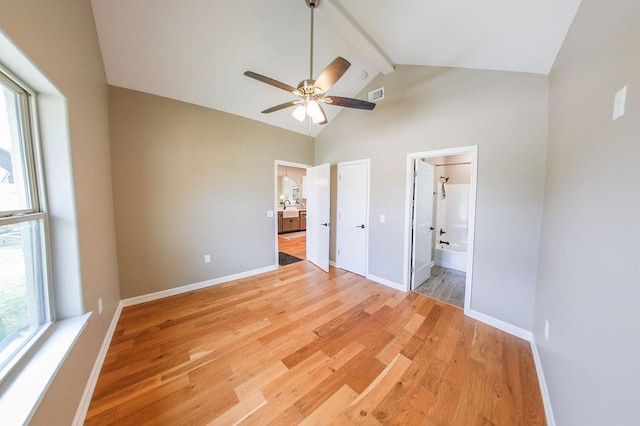 unfurnished bedroom with beamed ceiling, visible vents, multiple windows, and light wood-style floors