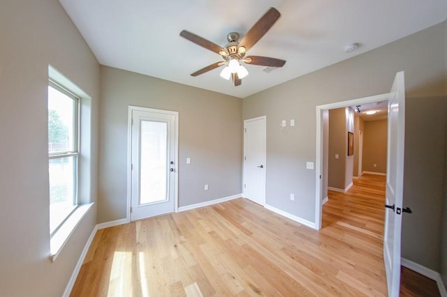 unfurnished bedroom featuring light wood-style floors, baseboards, and ceiling fan