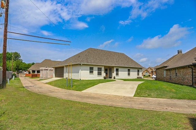 rear view of house featuring a yard, stucco siding, driveway, and a garage