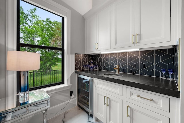 bar with backsplash, beverage cooler, wet bar, and a sink