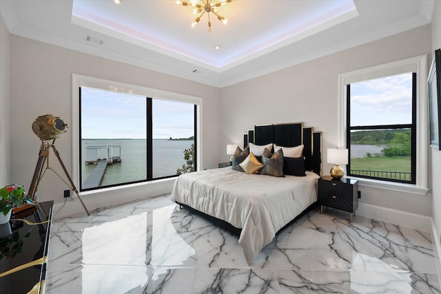 bedroom featuring visible vents, a water view, a chandelier, and a tray ceiling