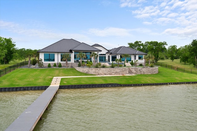 rear view of property with a water view, a fenced backyard, and a yard
