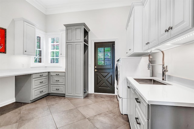 kitchen featuring ornamental molding, light countertops, gray cabinets, a sink, and light tile patterned floors