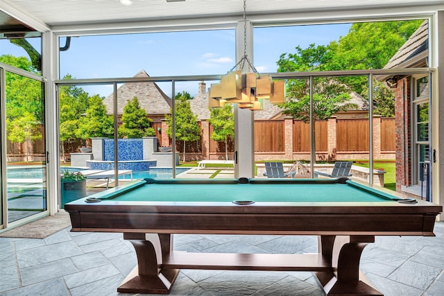 game room featuring pool table, a wealth of natural light, and stone tile floors