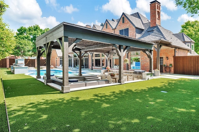 rear view of property with brick siding, a fenced backyard, exterior kitchen, and a yard
