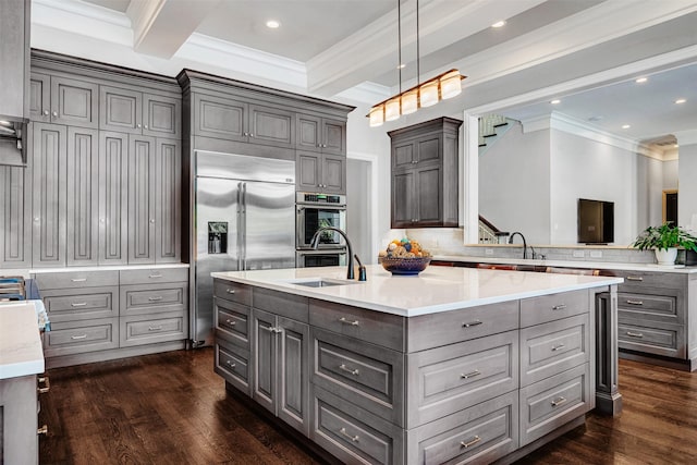 kitchen with gray cabinetry, crown molding, stainless steel appliances, and a sink