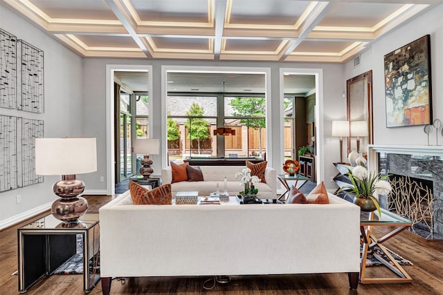 living area featuring a fireplace, coffered ceiling, wood finished floors, and a wealth of natural light