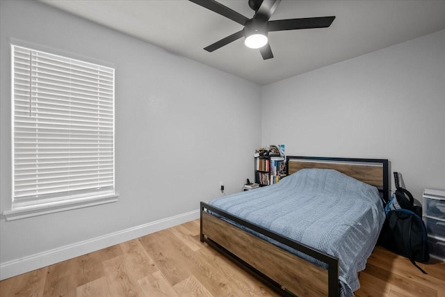 bedroom featuring light wood-style floors, baseboards, and ceiling fan
