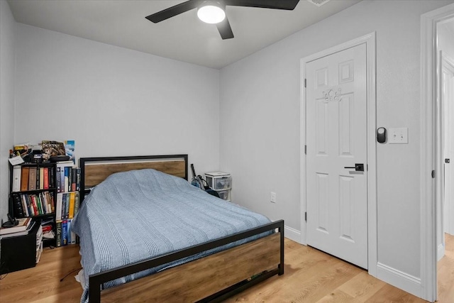 bedroom featuring light wood-type flooring, baseboards, and ceiling fan