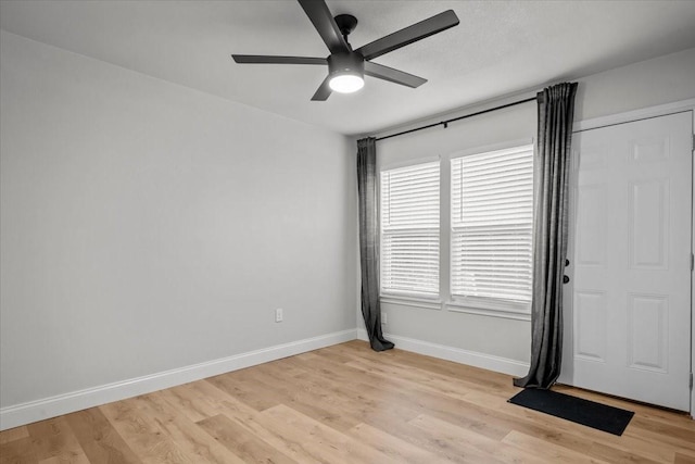unfurnished room featuring a ceiling fan, baseboards, and light wood-style floors