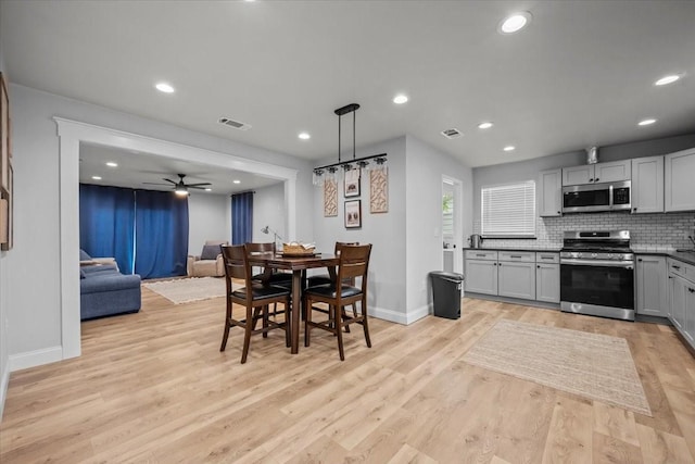 kitchen featuring visible vents, appliances with stainless steel finishes, tasteful backsplash, baseboards, and light wood-style floors