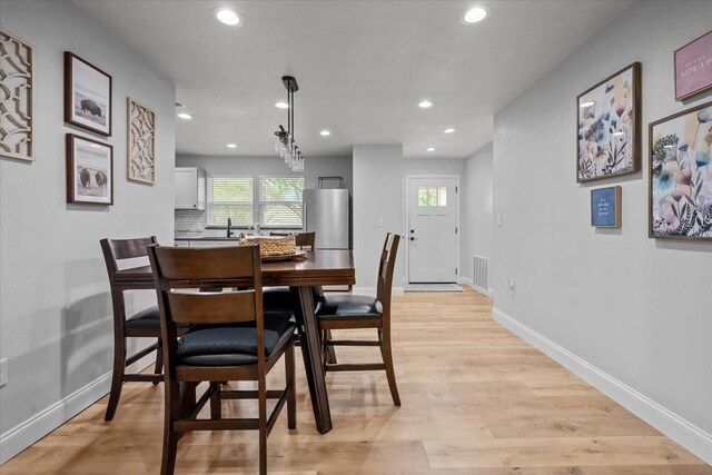 dining space featuring light wood-style floors, baseboards, recessed lighting, and visible vents