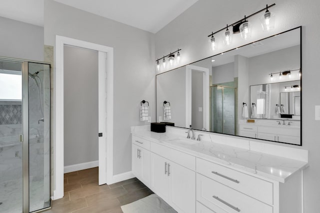 bathroom featuring baseboards, a stall shower, and vanity
