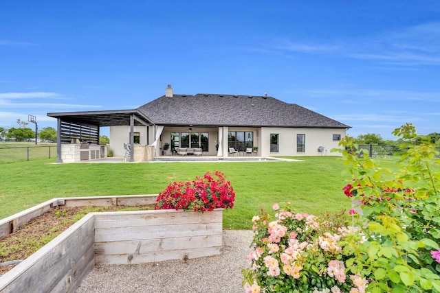 back of property with ceiling fan, a chimney, a lawn, fence, and a patio