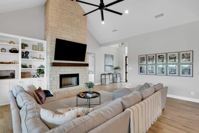 living room with visible vents, light wood-style flooring, ceiling fan, and high vaulted ceiling