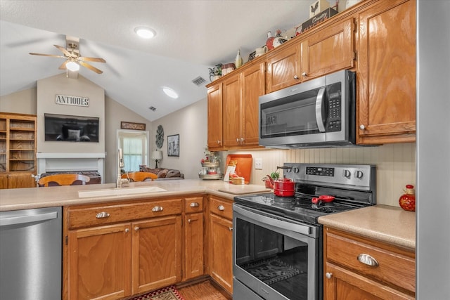 kitchen with visible vents, a sink, light countertops, open floor plan, and stainless steel appliances