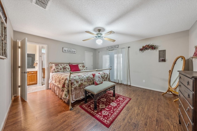 bedroom with baseboards, a textured ceiling, visible vents, and wood finished floors
