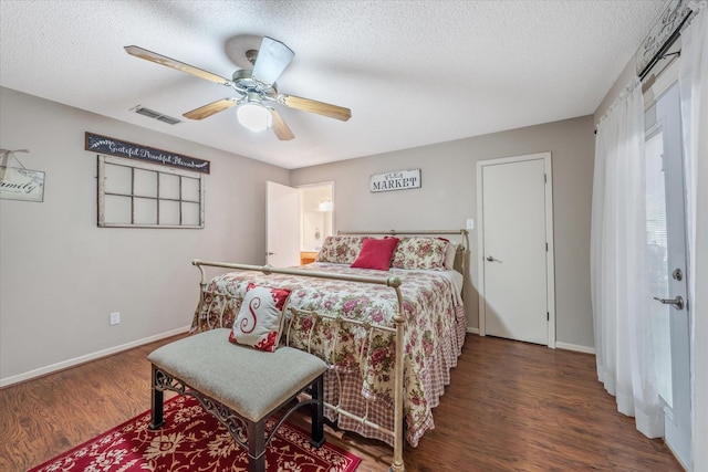 bedroom with baseboards, a textured ceiling, visible vents, and wood finished floors