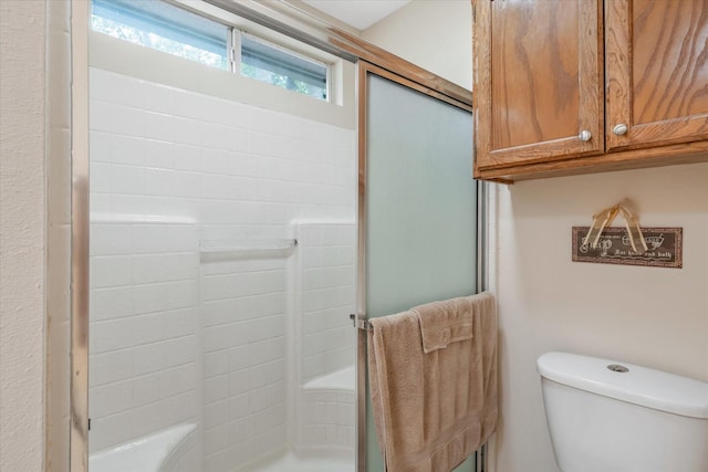 full bath with a shower with shower door and toilet