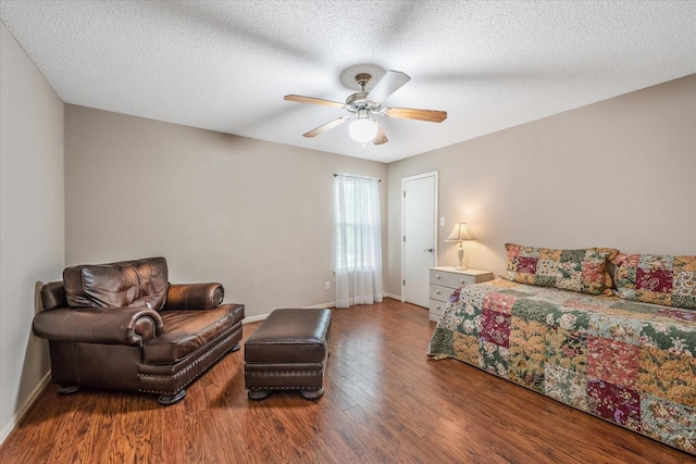 bedroom featuring baseboards, a textured ceiling, ceiling fan, and wood finished floors