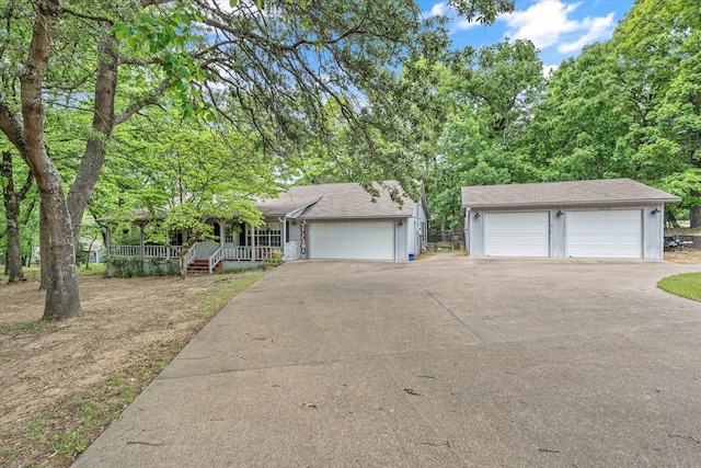 single story home featuring a porch and a detached garage