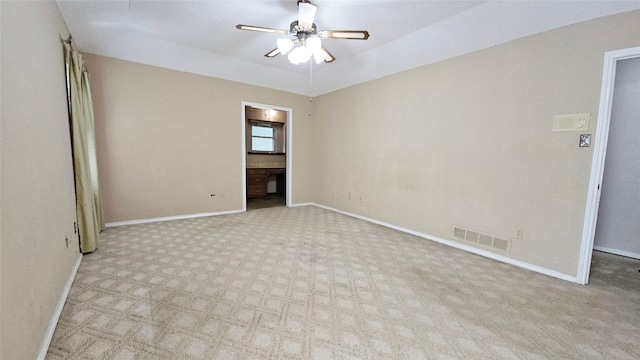 empty room with carpet floors, ceiling fan, visible vents, and baseboards