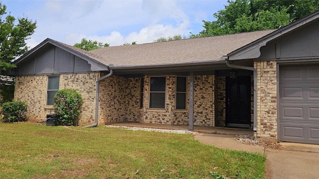 ranch-style house with an attached garage, roof with shingles, covered porch, and a front yard