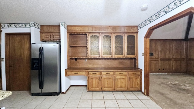 kitchen featuring open shelves, stainless steel refrigerator with ice dispenser, a textured ceiling, tasteful backsplash, and arched walkways