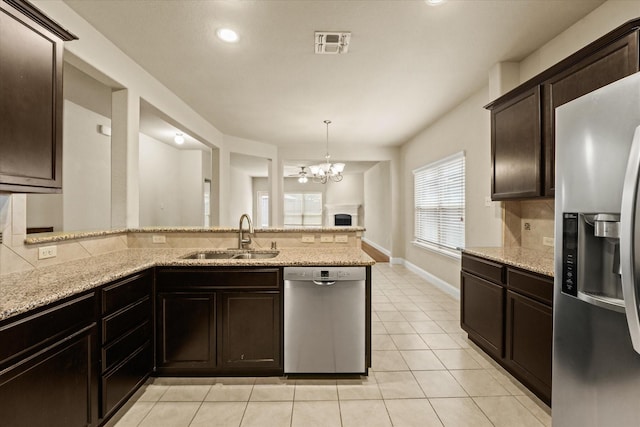 9933 Cottontail Ln, Mckinney, TX 75071 - kitchen featuring stainless steel appliances, a sink, light tile patterned floors, a chandelier, and light stone counters