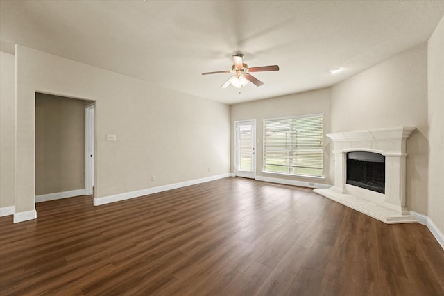 9933 Cottontail Ln, Mckinney, TX 75071 - unfurnished living room featuring a ceiling fan, dark wood-style floors, baseboards, and a premium fireplace