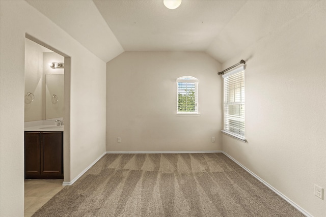 9933 Cottontail Ln, Mckinney, TX 75071 - unfurnished bedroom with a sink, light carpet, vaulted ceiling, ensuite bath, and baseboards
