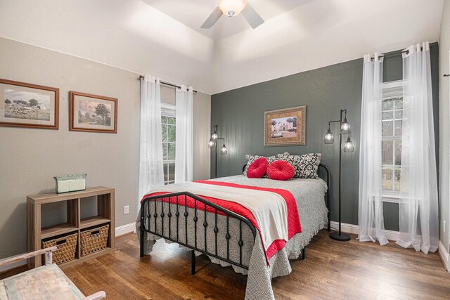 bedroom with baseboards, ceiling fan, and wood finished floors
