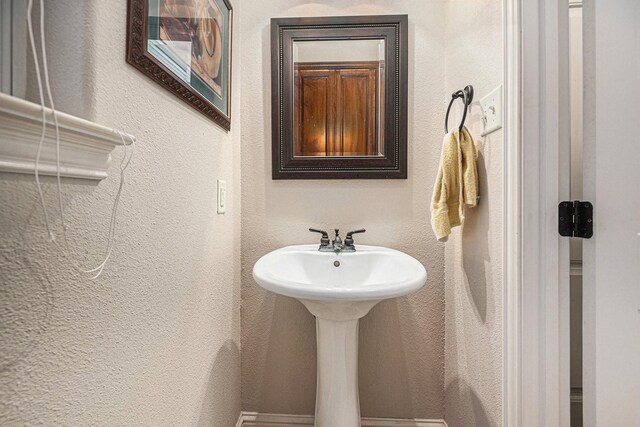 bathroom with a sink and a textured wall