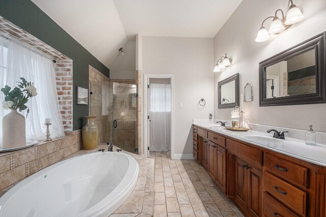 bathroom with a garden tub, a sink, a stall shower, and vaulted ceiling