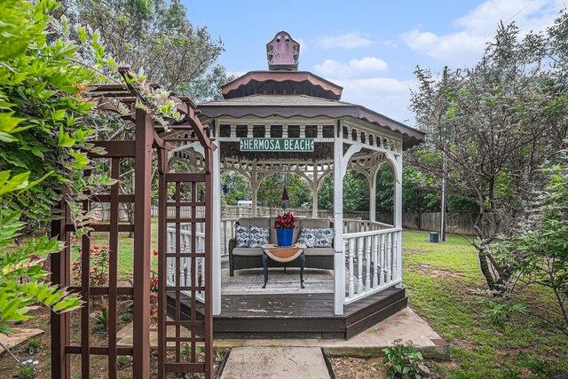 wooden terrace with a gazebo, a lawn, and fence