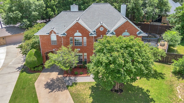 2085 Idlewood Dr, Grapevine, TX 76051 - view of front of house featuring a chimney, brick siding, roof with shingles, and a trampoline