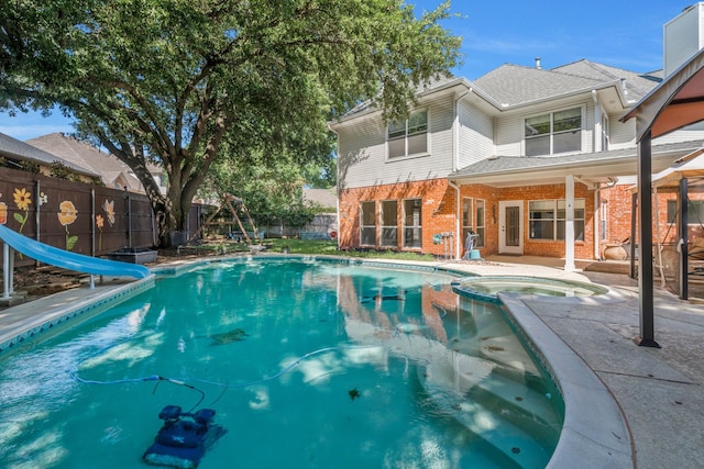 2085 Idlewood Dr, Grapevine, TX 76051 - view of swimming pool featuring a water slide, a fenced backyard, a pool with connected hot tub, and a patio