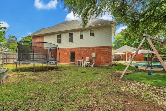2085 Idlewood Dr, Grapevine, TX 76051 - rear view of property with a trampoline, brick siding, and a fenced backyard