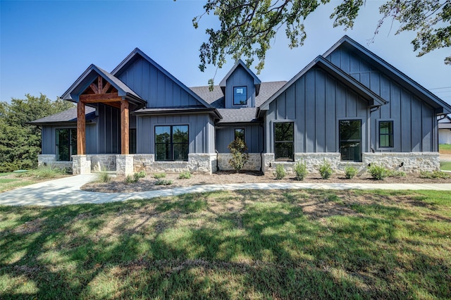 view of front of property featuring a shingled roof, board and batten siding, and stone siding