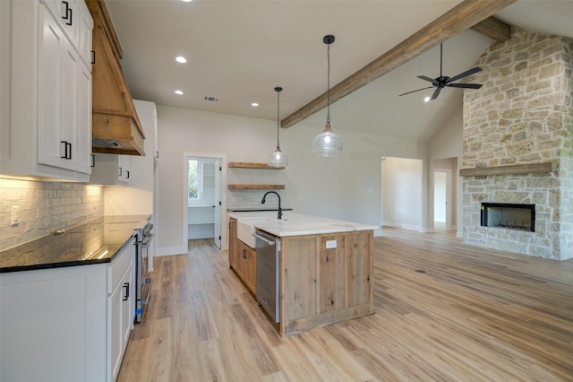 kitchen featuring decorative backsplash, open shelves, a sink, light wood finished floors, and open floor plan