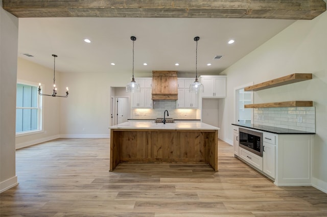 kitchen with open shelves, a sink, light wood finished floors, and white cabinetry