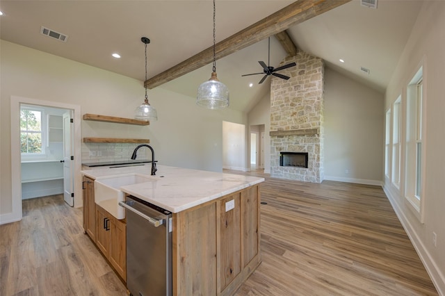 kitchen featuring visible vents, light wood-type flooring, beam ceiling, dishwasher, and a sink