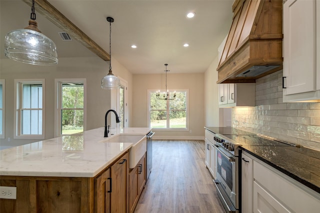 kitchen featuring visible vents, a sink, premium range hood, stainless steel appliances, and recessed lighting