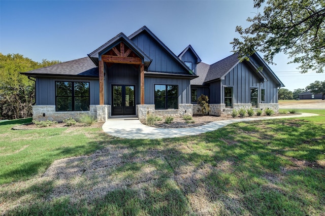 view of front of home with french doors, board and batten siding, roof with shingles, and stone siding