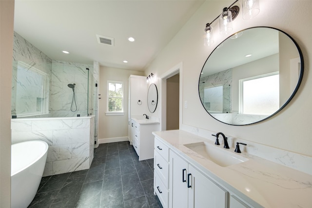 full bath with a sink, a marble finish shower, recessed lighting, a freestanding tub, and visible vents