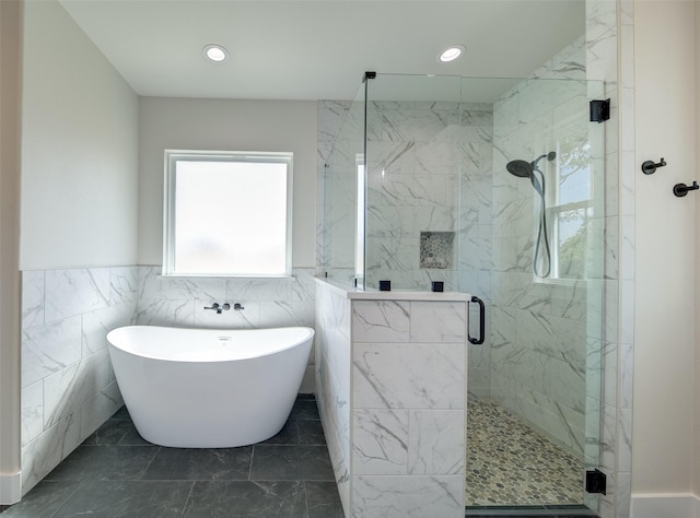 full bath featuring a freestanding bath, a wainscoted wall, a shower stall, and recessed lighting
