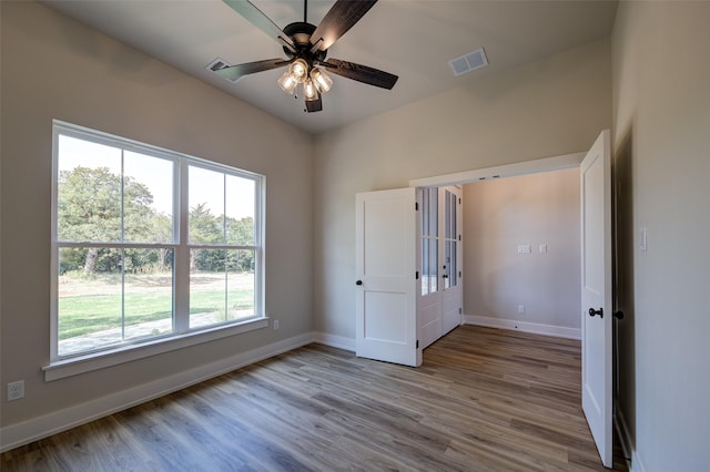unfurnished bedroom with baseboards, wood finished floors, and visible vents